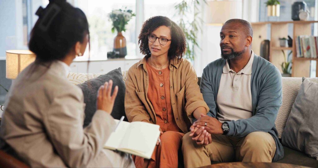 A couple attentively listens during a counseling session.
